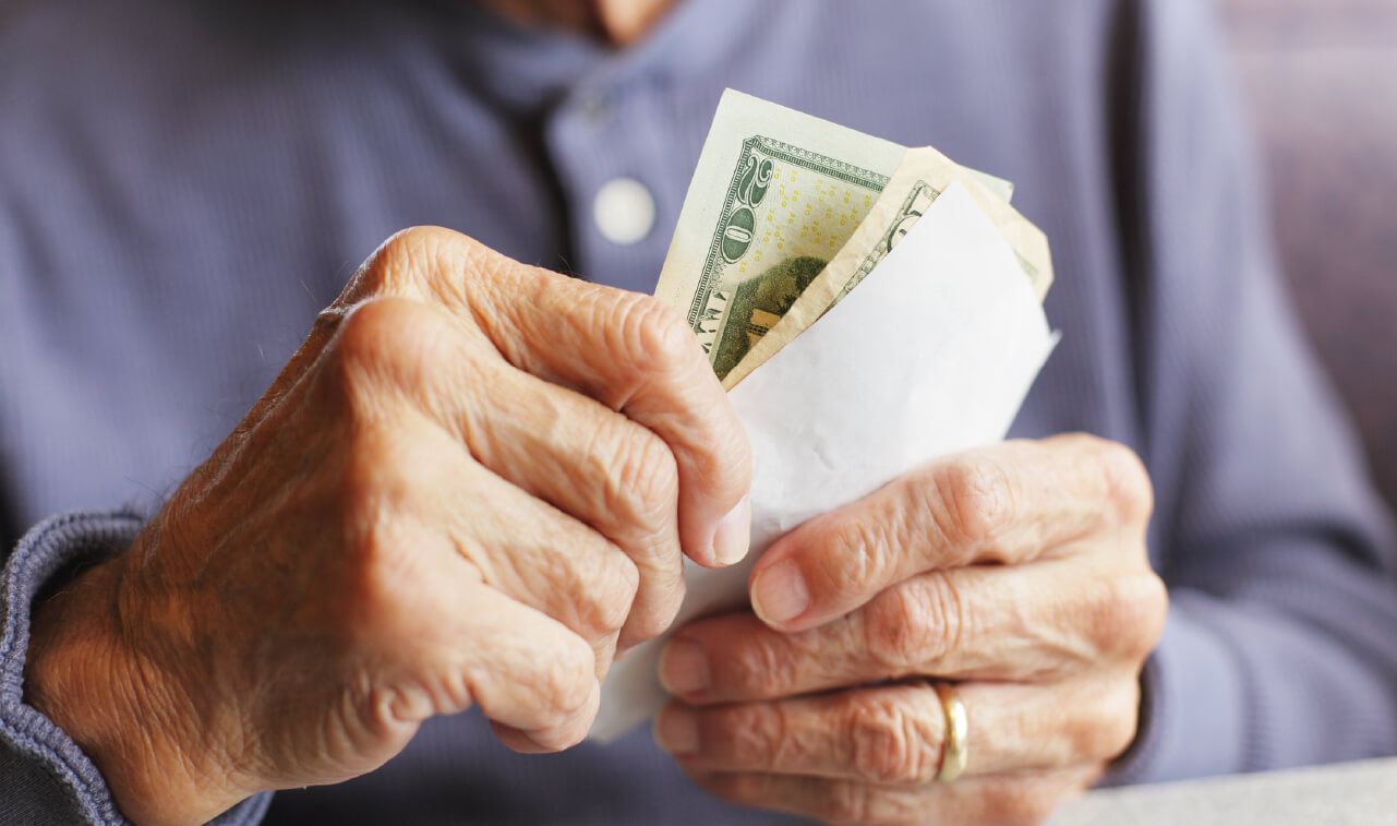 Older man holding cash in his hands