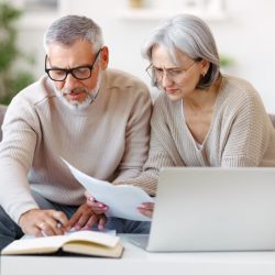 Couple working on taxes with laptop and papers