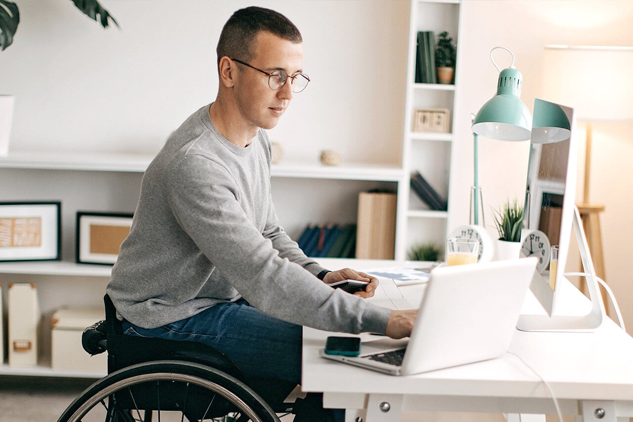 Man in wheelchair looking at laptop