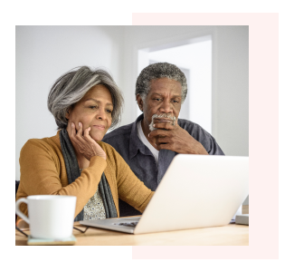 Older couple looking at laptop together, reading about retirement planning